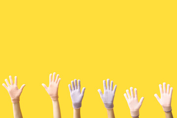 Female hands in stylish warm gloves on yellow background