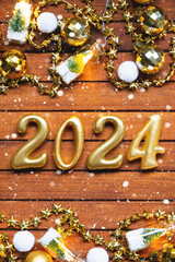 Happy New Year wooden numbers 2024 on cozy festive brown wooden background with sequins, snow,...