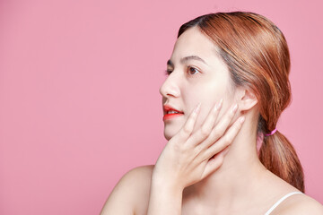 Fototapeta premium Beauty asian woman face portrait. beautiful model girl with perfect fresh clean skin color lips red. Facial treatment. Face care, Cosmetology , beauty and spa. Isolated on pink background.