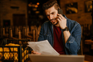 Cafe owner reviewing accounts and using a laptop