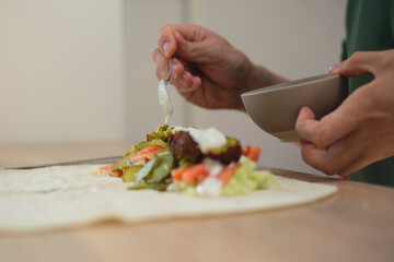Man cooking homemade falafel meal.