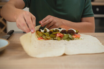 Man cooking homemade falafel meal.