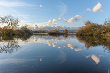Line of clouds reflecting in a flooded meadow after heavy rains. Autumn landscape.