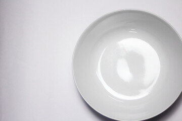Empty white plate on white background with copy space. Top view.