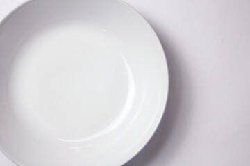 Empty white plate on white background with copy space. Top view.
