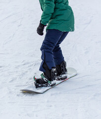 A man snowboards in the snow in winter