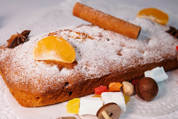 Christmas cake. Christmas stollen with dry fruits, cinnamon, stars, cinnamon sticks, pine twig, nuts. New Year