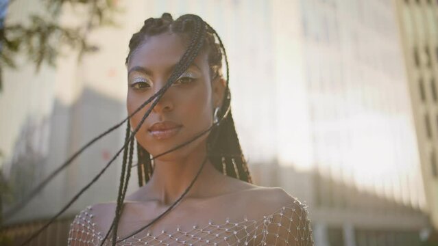 Afro braids girl posing windy street portrait. Dreadlocks woman looking camera