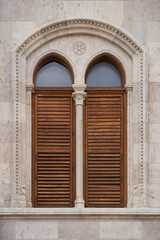 Window with wooden shutters built in neo-gothic style. Exterior of the Hungarian Parliament Building (Hungarian: Országház). Budapest, Hungary - 7 May, 2019