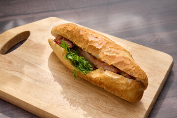 Banh Mi Heo Quay.Vietnamese bread with roasted pork and fresh herbs as scallions, coriander,...