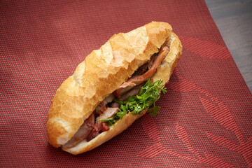 Banh Mi Heo Quay.Vietnamese bread with roasted pork and fresh herbs as scallions, coriander,...