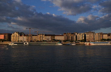 Fototapeta premium Beautiful panorama of Danube river embankment at sunset. Tourist cruise ships in Budapest, Hungary - 7 May, 2019