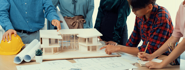 Architect team analysis and brainstorming about house construction at meeting table with house...
