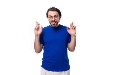 Fototapeta premium young handsome caucasian man with dark well-groomed hair and beard dressed in a blue t-shirt