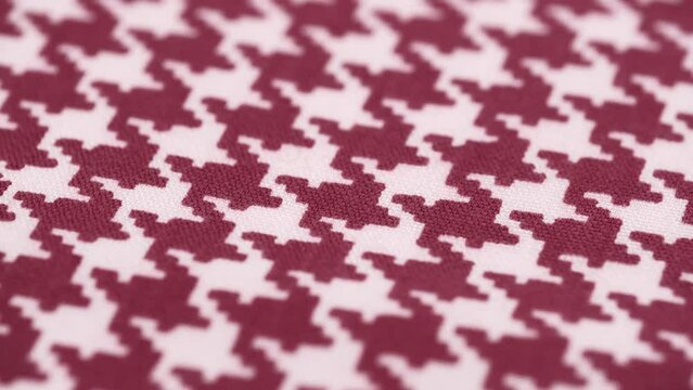 closeup of drawing on cotton fabric houndstooth, classic pattern, rotating. burgundy-white houndstooth pattern. textile background. concept of weaving production, factory.