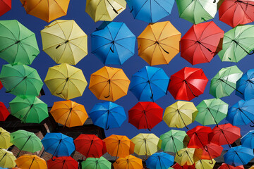 Colorful umbrellas over the main street in L' Aigle, Orne, France - obrazy, fototapety, plakaty