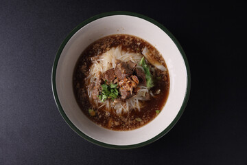 Braised pork noodles Thai street food isolated in black background
