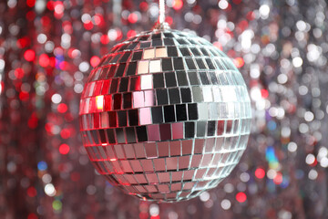 The disco ball is illuminated with red light