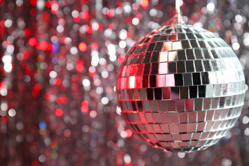 The disco ball is illuminated with red light
