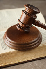 Book and judge's gavel on gray background, close up