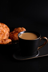 Hot latte coffee with Croissant coffee break isolated in black background