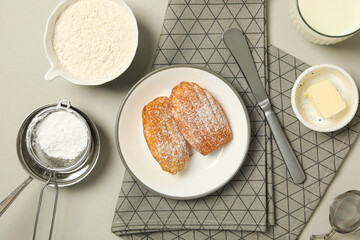 Madeleine cakes, flour, butter and towel on light background, top view