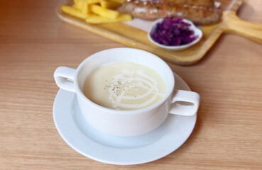 Cream of Mushroom Soup on wooden table close up and selective focus.