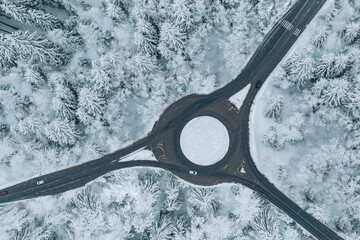 Aerial view of a traffic roundabout and road junctions in snow winter  forest - obrazy, fototapety, plakaty