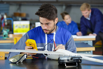 trainee aircraft engineer using a multimeter