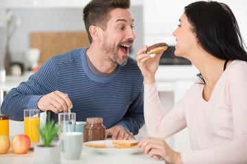 young couple smiling and laughing as they share food