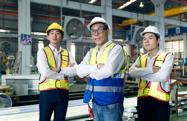 Portrait Team of Asian male engineers and technicians in safety helmets and wearing safety vests...