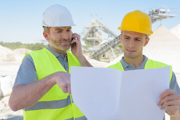 two workmen discussing project plans in factory