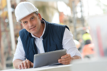 cement manufacturing manager holding tablet