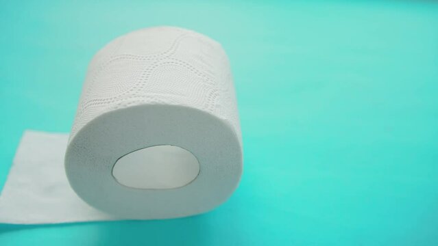 A roll of high-quality soft toilet paper with perforations on a blue background. The concept of multi-layer cellulose toilet paper, care and hygiene. Copy space for text