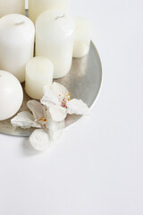 Christmas Still Life Composition with White Candles and Dry Orchid Flowers on Tray.  White Christmas Background. 