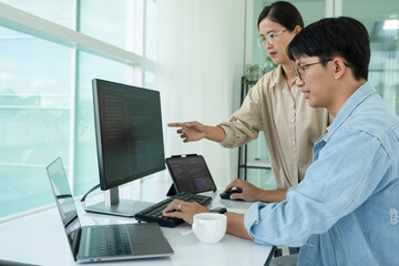 IT programmers working together at office desk.