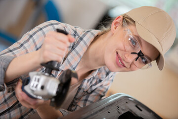 Fototapeta na wymiar female worker using glasses saws with a circular saw