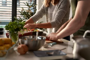 Poster Restaurant Caucasian couple preparing food before Christmas  © gpointstudio