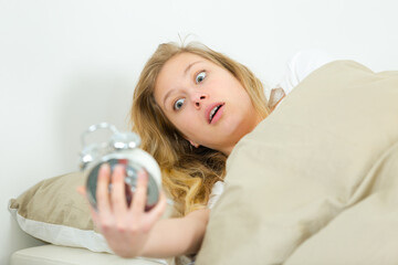 girl overslept and she is shocked about the time