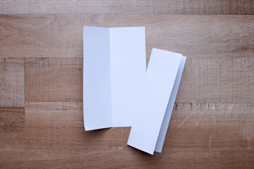 Bifold white template paper on wooden background