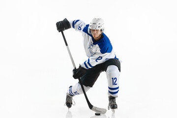 Champion. Young man, hockey player during game, training, playing against white studio background