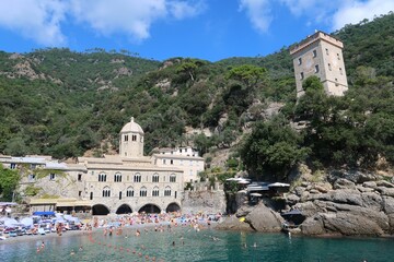 Paysage à San Fruttuoso en Ligurie, sur la Riviera italienne, au bord de la mer Méditerranée, avec une abbaye et une tour au bord de la plage (Italie)