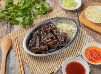 caramel rice roll bars with chilli sauce, noodles, spoon and chopsticks served in dish isolated on napkin top view of hong kong food