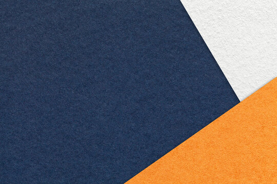 Texture of craft navy blue color paper background with white and orange border. Vintage abstract denim cardboard.