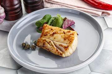 Roasted cod fish steak with salad