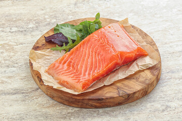 Raw salmon fillet over board