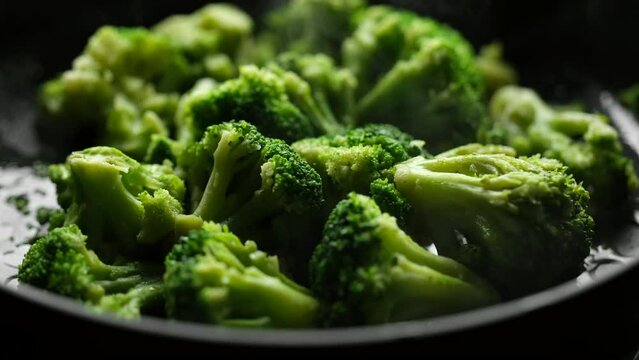 Fresh broccoli frying on a pan. Healthy food, vegetarian cuisine