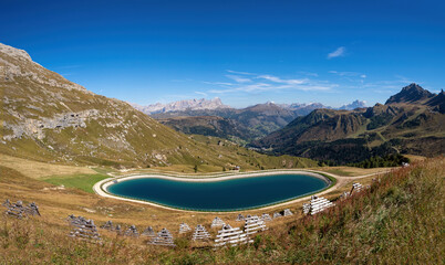 Artificial water catchment reservoir for snow skiing slopes at Dolomites in Italy.