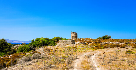 Landscape on the Greek island of Kos with a ruin of an old windmill.
