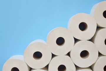 Many rolls of toilet paper on a blue background.  Free space for text.
